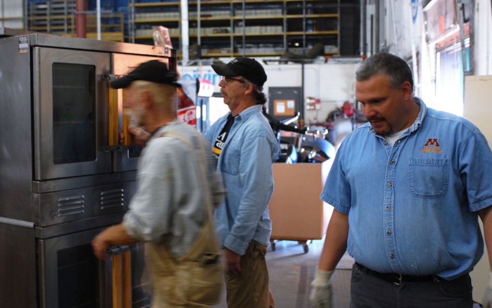 ReUse warehouse manager Chris Hruza (right) looks for a spot to put a used convention oven Wednesday. The 20,000-square-foot warehouse contains everything from dentist chairs to old office furniture.