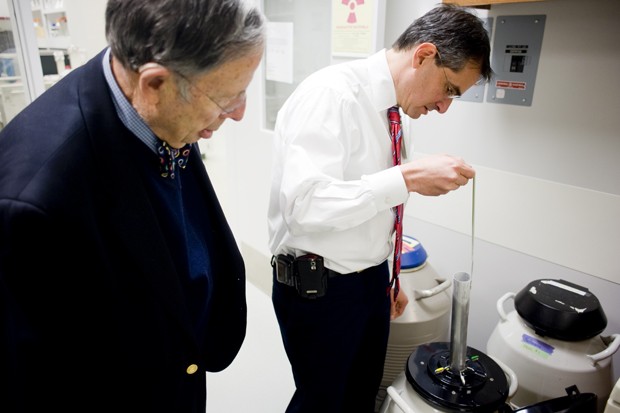 Retired professor of surgery Arnold Leonard, left, and assistant professor Daniel Saltzman, right, pull out frozen cancerous pancreas cells in the Phillips Wangensteen Building Tuesday. The cells will later be used to study the effects of salmonella on treating the tumors. 