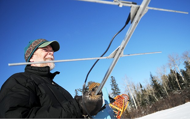 University alumnus Mike Nelson uses a radio receiver to track the location of the Birch Lake pack of wolves after discovering a kill on the lake shore. 