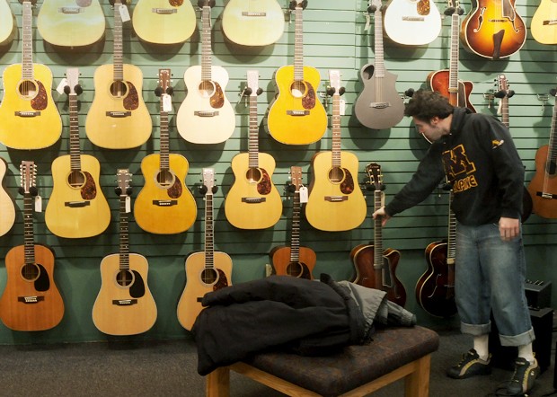 A customer shops for instruments in the basement level of The Podium, a family-owned Dinkytown guitar shop open since 1959.