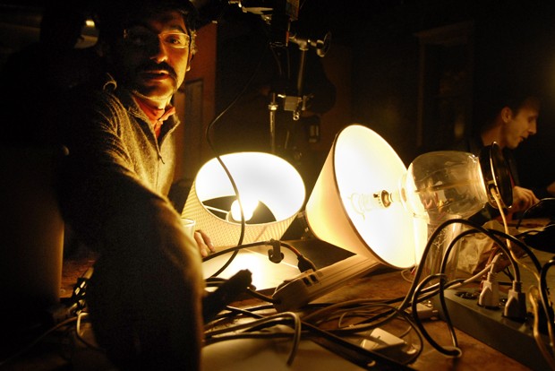 University Professor Ali Momeni displays a light projection Wednesday at the West Bank Social Center. Momeni teaches Art on Wheels, a class and research initiative that lets students display art from bike-mobilized media disseminators.