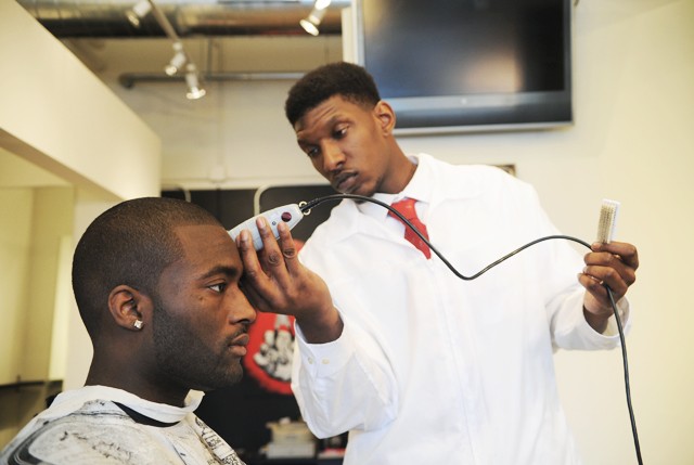 Barber Detronza Kirksey cuts Sports Management sophomore Hakeem Onafowokan’s hair Wednesday at Clique’s Barbershop. The Dinkytown business donated Wednesday’s earnings to relief efforts in Haiti. 