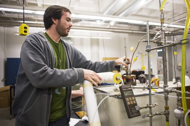 University graduate student Brandon Hathaway explains the process of biomass gasification Monday in the Mechanical Engineering building. 