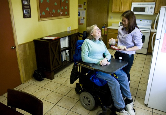 Rhea Igao, a former U of M student, helps resident Teresa Linberb in a Roseville home on Tuesday. ACR Homes is a company that provides housing and assistance for people with physical and mental disabilities.