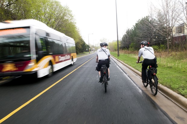 University Bike Patrolmen Kevin Scott, left, and Corey Onderick bike on the transit way to St. Paul.