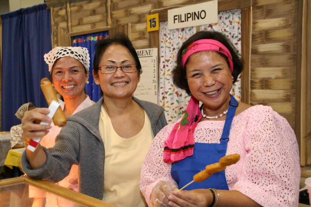 A group of Filipino women offer the cameraman traditional food.
PHOTO COURTESY ALEKSANDRA TILL

