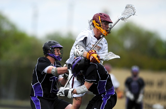 Minnesota senior Dan Wingard passes the ball while being hit by Mankato players on Saturday at Burnsville High School.