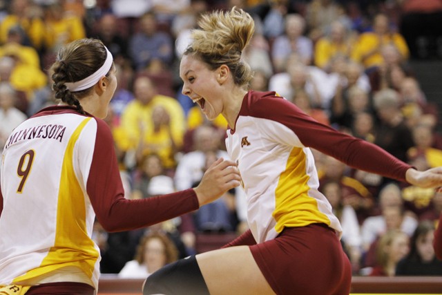 Gophers sophomore outside hitter Tabitha Love (left) and senior middle blocker Lauren Gibbemeyer celebrate after scoring a point against Dayton on Saturday at the Sports Pavilion. 
