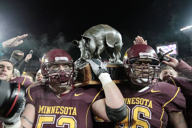 Senior D.J. Burris, left, and Junior Brandon Kirksey hold up the Floyd of Rosedale trophy after their win against the Iowa Hawkeyes on Saturday at the TCF Bank Stadium.  It was the Gopher’s first trophy win since 2006.