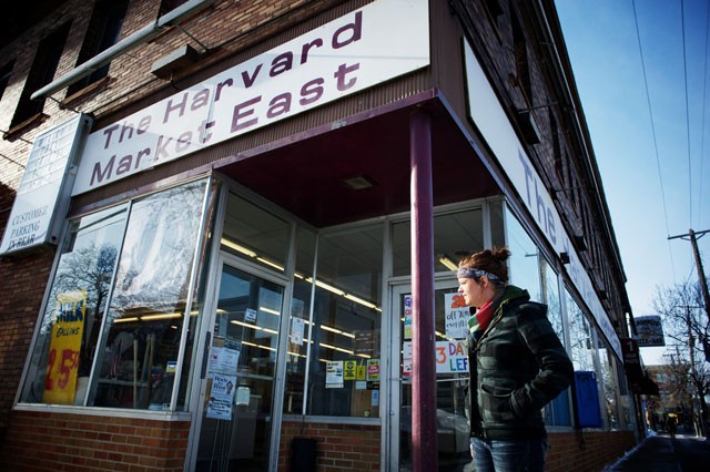 Assistant Manager Dana Kabitzki takes a cigarette break Saturday outside the Harvard Market in Stadium Village.  The corner store will close after 106 years of operation on campus.