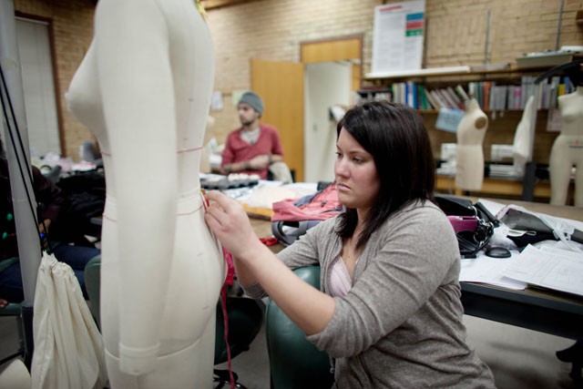Fashion design senior Jessica George measures the waist of a mannequin Monday at the McNeal Center in St Paul. 