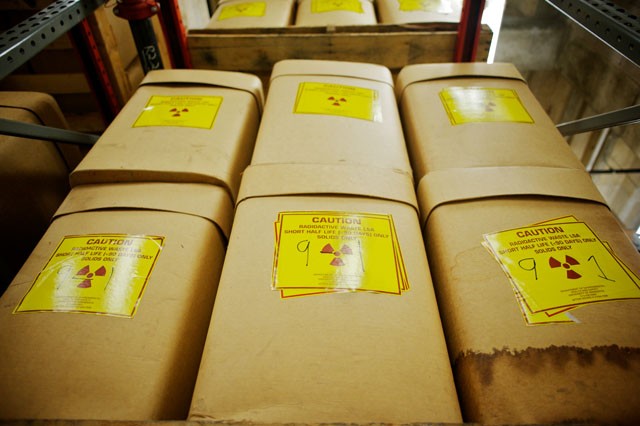 Hundreds of cardboard boxes containing low-level radioactive waste line storage racks Friday at the Thompson Center.  The boxes are filled mostly with objects like gloves from labs that work with radioactive materials.