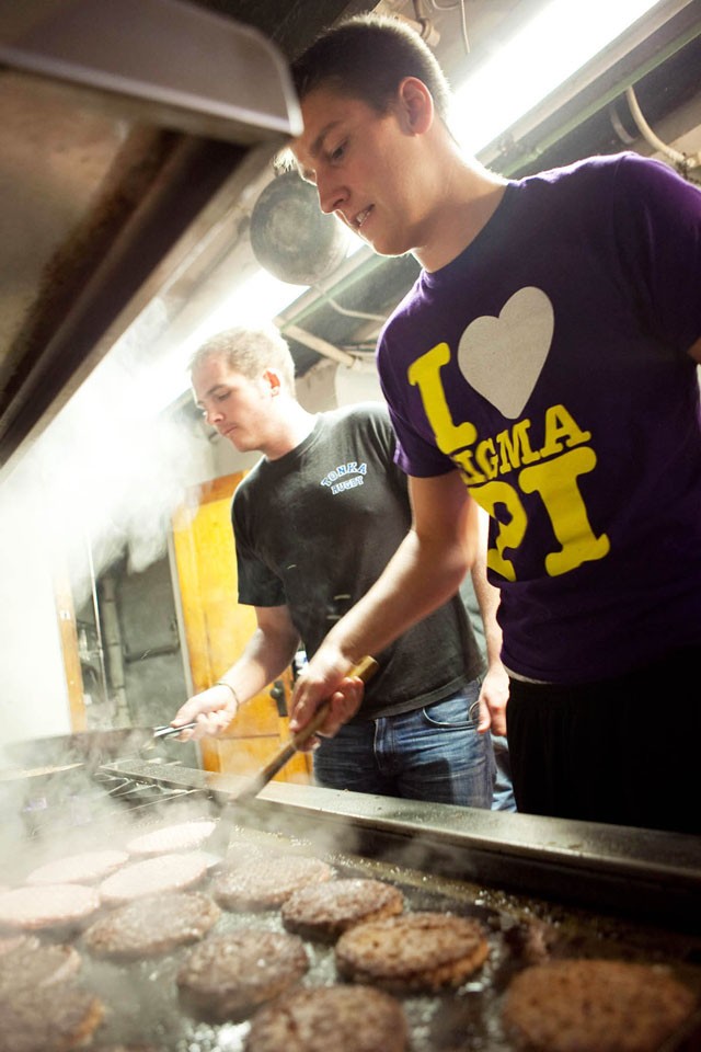 Sigma Pi member Travis Brevig cooks burgers Friday afternoon for the dinner Sigma Pi hosted honoring University custodians and grounds workers.