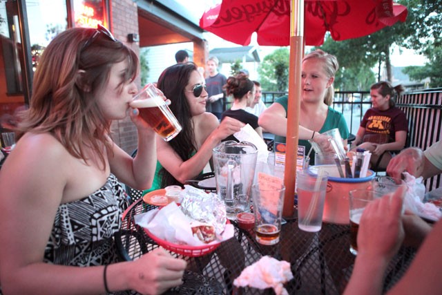 Annie Padovese, left, sips a Surly with Eleni Ayo Caros, center, Lana Hogan, right, and friends Sunday afternoon on the patio at Burrito Loco.
