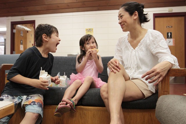 Elijah Biggss, left, jokes with his sister Angelina and mother Keiko over lunch Monday at Van Cleve Community Center. The family plans to take advantage of the community services program at Van Cleve Park by receiving free lunches there several times per week.