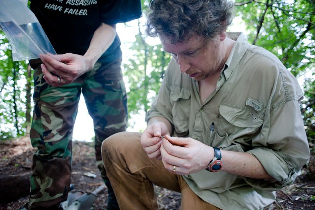 Curator of archaeology at the Science Museum of Minnesota Ed Fleming examines a shard of pottery discovered by one of his students Monday at the Bremer Village site. The students spend over 30 hours a week working at the site.