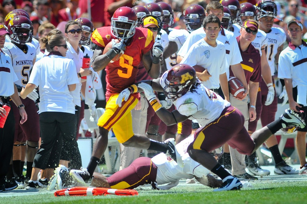 Gophers senior defensive back Kim Royston tackels Trojans wide reciever Marqise Lee.