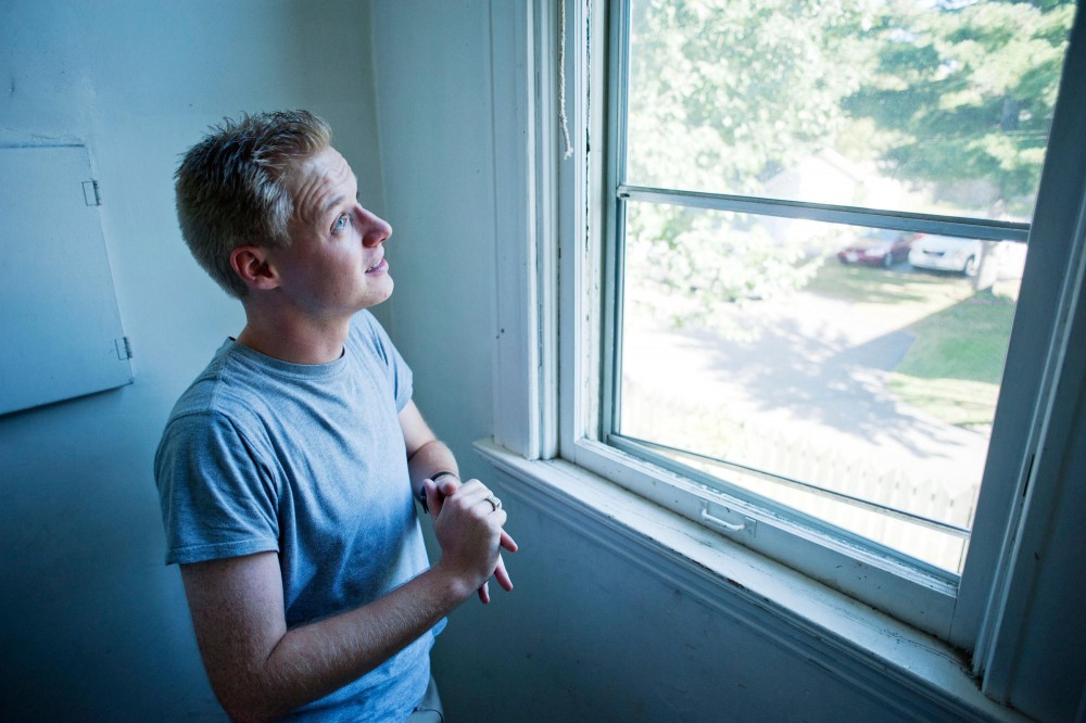 Neal Fredrickson examines a broken screen Monday in his Marcy Holmes apartment.  Fredrickson feels the property owner has been slow in responding to his maintenance requests.