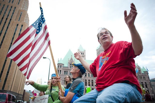 Don Dixon waves to traffic Friday at the Hennepin County Government Center.  Dixon said he is frustrated by a growing disparity of wealth and losses of jbs and homes in America.