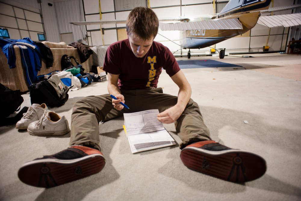 Winsted, Minn. - Nov 5 -Computer science junior AJ Stuyvenberg reviews his jump log in preperation of testing for a United States Parachute Association B license in the hanger of Westside Skydivers.  The B license will allow Stuyvenberg to deploy his parachute at a lower altitude.