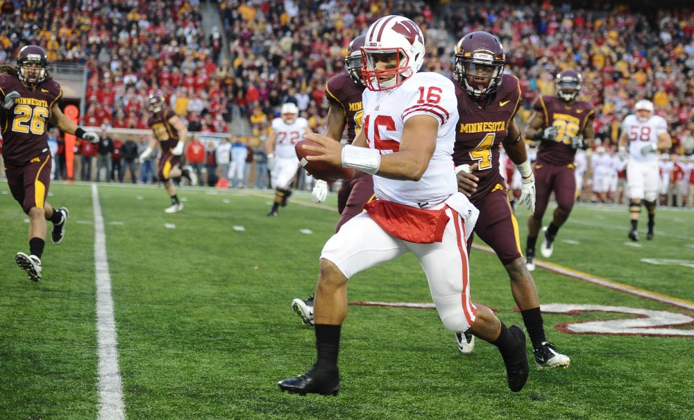 Wisconsin quarterback Russell Wilson dashes out-of-bounds during Saturdays game against Minnesota at TCF Bank Stadium.