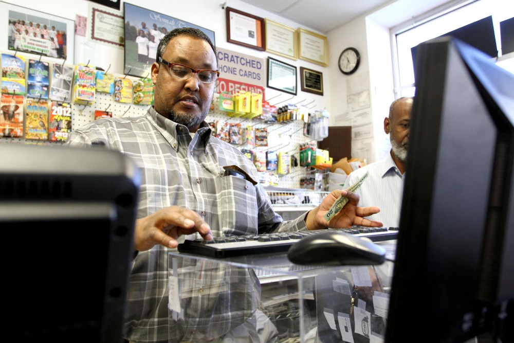 Owner Abdi Adem makes a transaction Monday morning at Afrik Grocery and Halal Meat on Cedar Avenue. Adem was able to expand his business through the city of Minneapolis Alternative Financing Program. 
