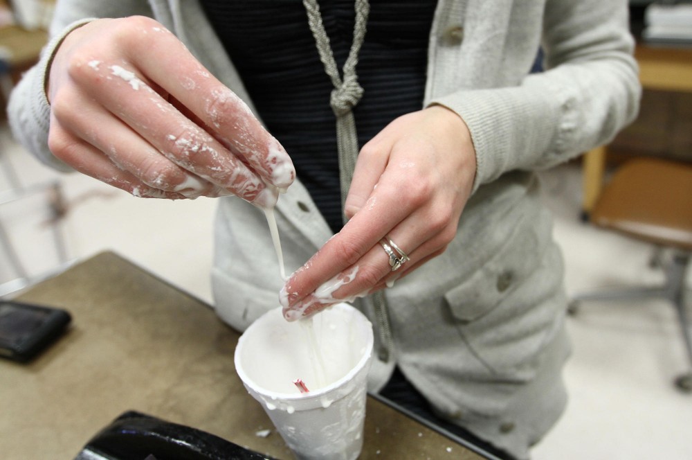 Apparel design junior Ellie Hottinger plays with a mixture of cornstarch and water Tuesday in McNeal Hall in a class designing a spacesuit. The class is currently working on materials relating to mobility and impact protection.