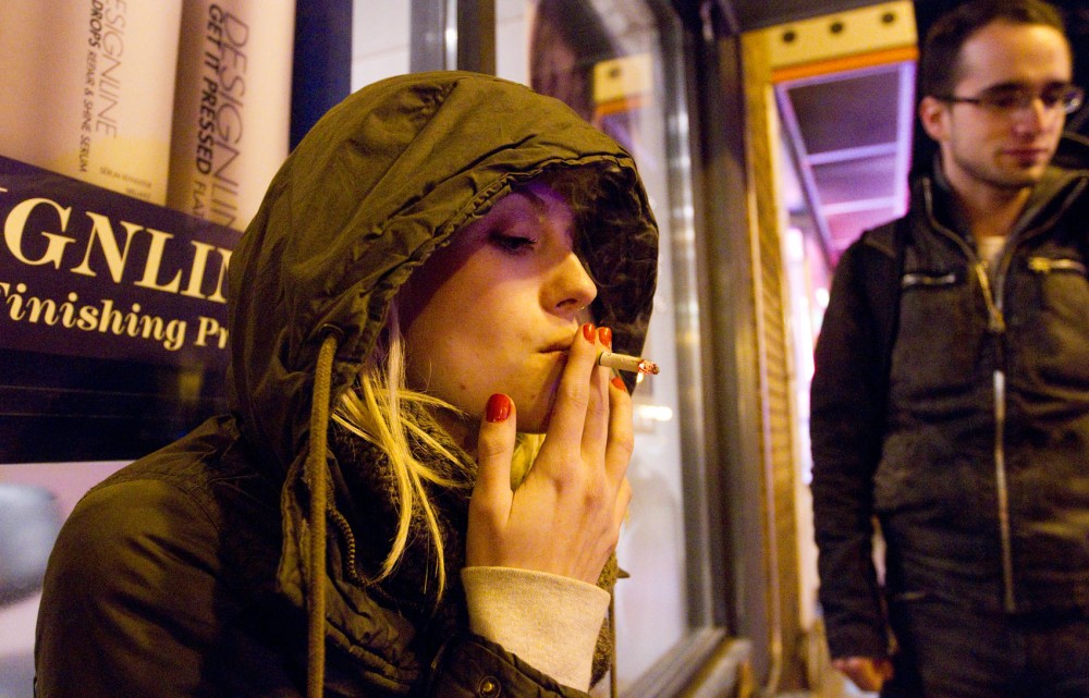 Art sophomore Lizzy Berard takes a smoke break late Thursday night with a friend while studying at Espresso Royale in Dinkytown. Berard has been smoking for four years and says a tax increase on cigarettes wouldn’t change how often she lights up.