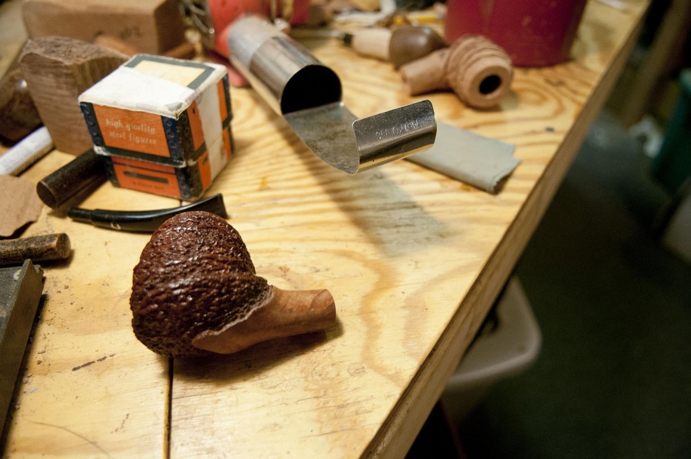 One of Rich Lewis earlier pipes sits on his workbench.  Lewis says it can take him anywhere between 6 to 20 hours to finish a pipe.