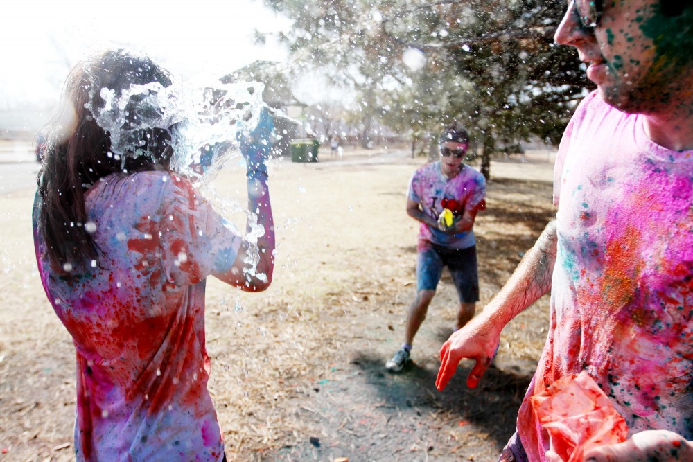Students fling water balloons and packets of vibrantly colored powder on Tuesday in Van Cleve Park in recognition of the Holi holiday. Holi is usually celebrated on the last full moon of winter as a multi-day festival.