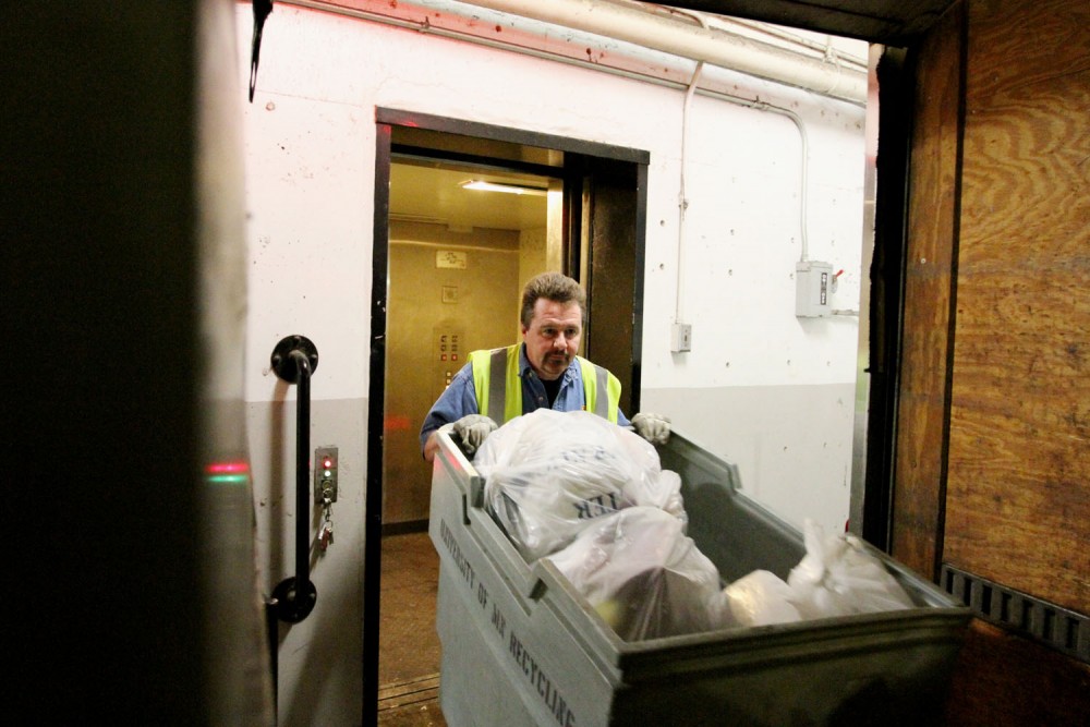 Chuck Schlichtmann transports recycling from the Centennial Halls loading dock into his recycling truck on March 21.