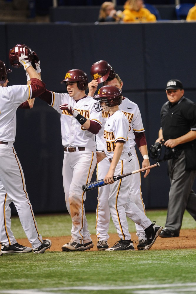 Minnesota catcher Matt Halloran celebrates with his team after hitting a two-run home run against Iowa on Friday at the Metrodome.