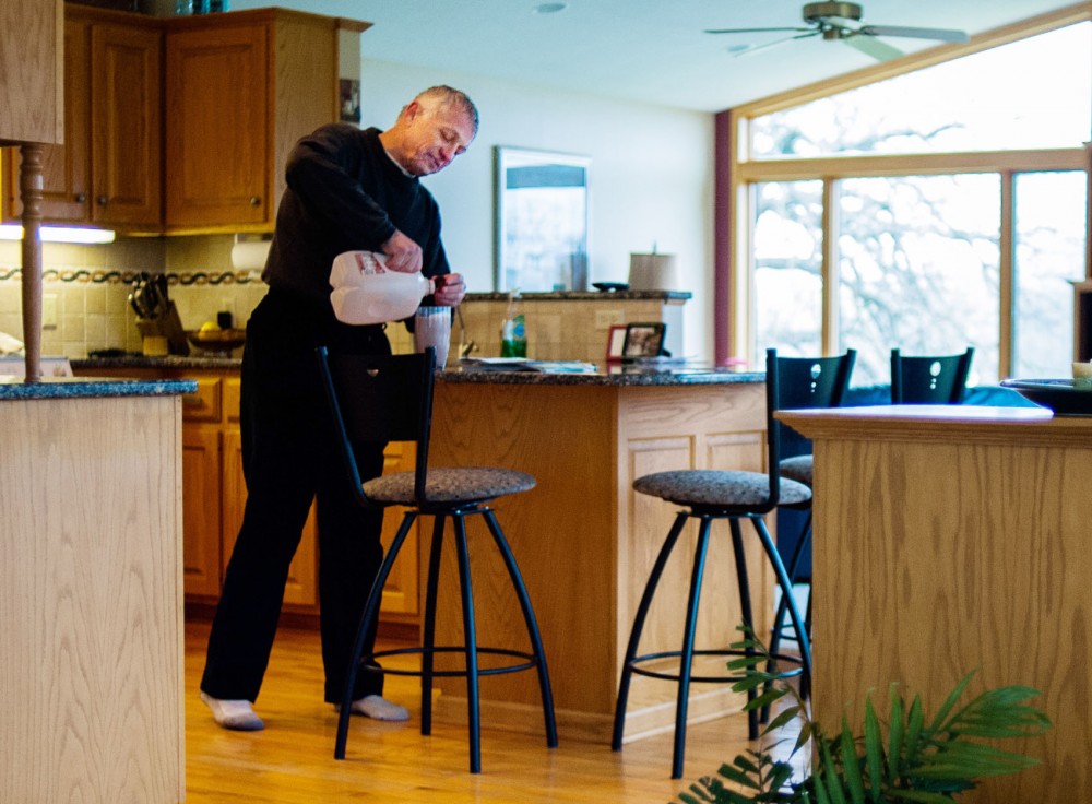 Steve Sviggum pours himself a glass of chocolate milk at his home Saturday in Kenyon, Minn.  Sviggum makes the hour-long commute to the Capitol in St. Paul five days a week.