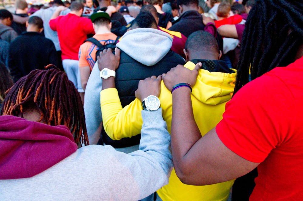 Students, friends and family of recently passed Minnesota linebacker Gary Tinsley gather and hold a group prayer Friday night outside of Roy Wilkins Hall.