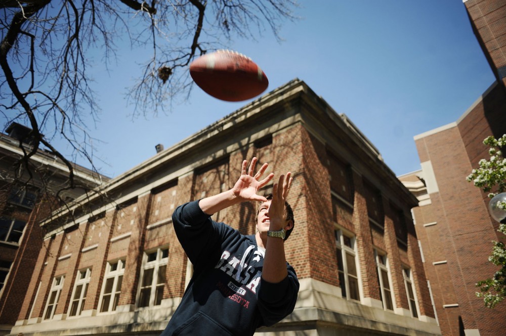 Electrical engineering senior Jamin Ivers tosses around a football with friends behind Lind Hall.