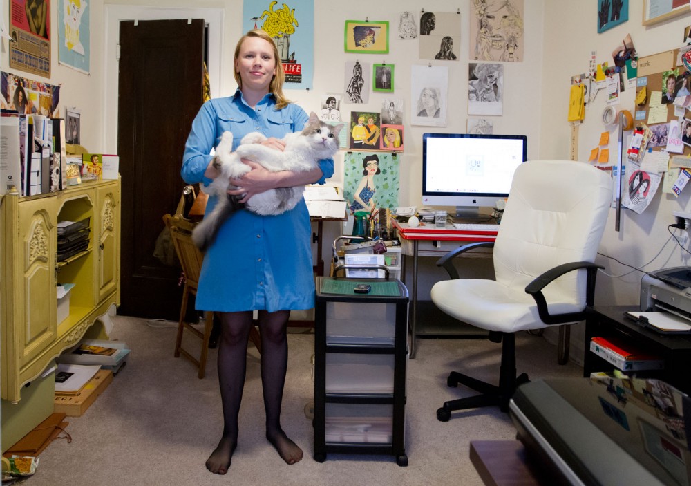 Illustrator and graphic designer Kelly Abeln holds her cat, Pebbles, on Friday in her home studio in south Minneapolis, where she creates pieces by hand and by computer for the online magazine Rookie.