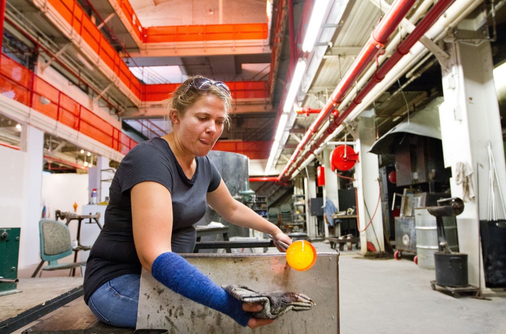 Charissa Peterson shapes a bulb of molten glass into a bowl Thursday at FOCI Minnesota Center for Glass Arts. FOCI, located in a building complex that used to be a General Mills research and development complex, is the only open studio for glass blowing in Minnesota where hobbyists can take classes and rent studio time.