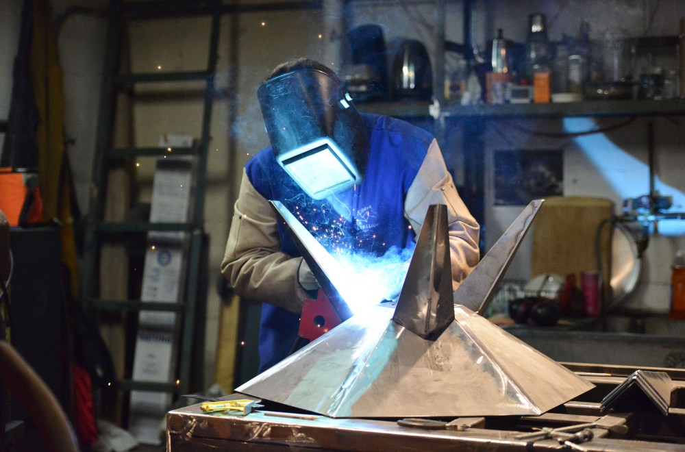 Sculptor and fabricator Asa Hoyt welds legs onto an outdoor fireplace unit Monday in his studio space at 2010 E. Hennepin Ave. Hoyt collaborates with other artists in the building on specific projects.