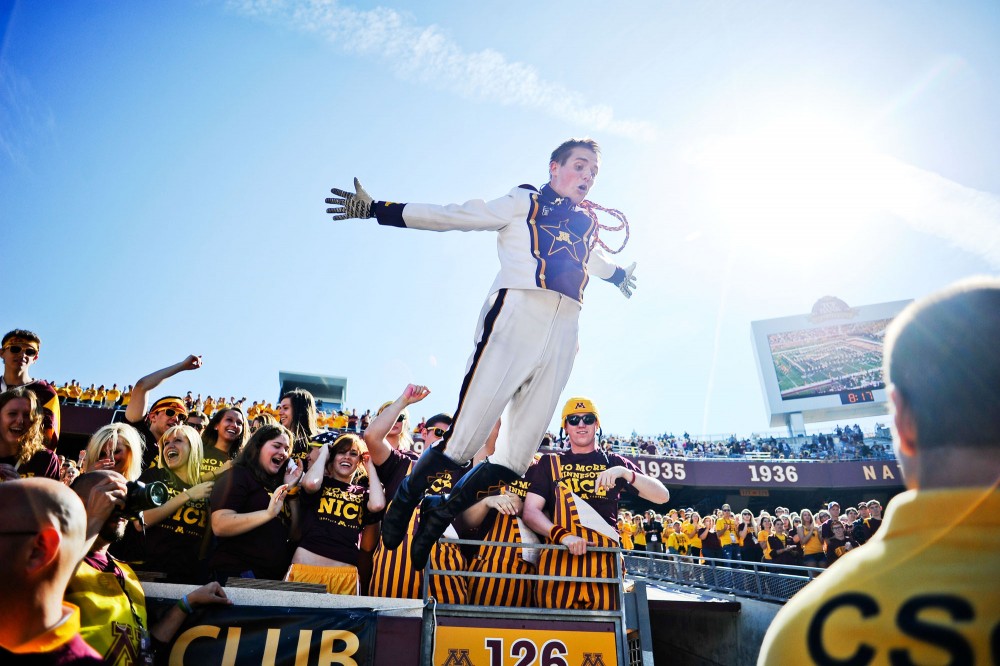 Minnesota marching band drum major Brandon Folkes dives from the student section before Saturday’s game against New Hampshire at TCF Bank Stadium.