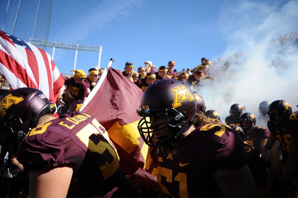 Minnesota players charge onto the field before the start of the Gophers home opener against New Hampshire on Saturday at TCF Bank Stadium.