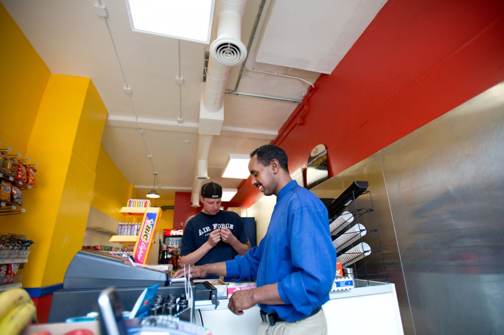 Ahmed Mohamed, owner of the newly opened U of M Market, rings up a customer in his store June 16.