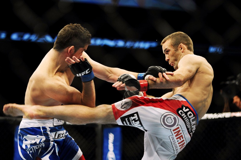 Former Minnesota wrestler Jacob Volkmann, right, lands a kick against his opponent, Shane Roller, during a UFC event Friday night at the Target Center. Volkmann, who graduated from the University with degrees in geology and geophysics, currently runs his own chiropractic practice in White Bear Lake, Minn. 