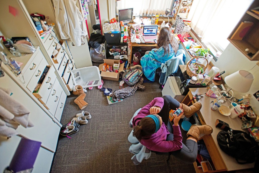 Dance freshman Alexandra Eady, bottom, and physiology freshman Natalie Kirchhoff relax in their shared single dorm room Sunday in Centennial Hall. Eady will eventually be relocated from expanded housing to a regular dorm arrangement.