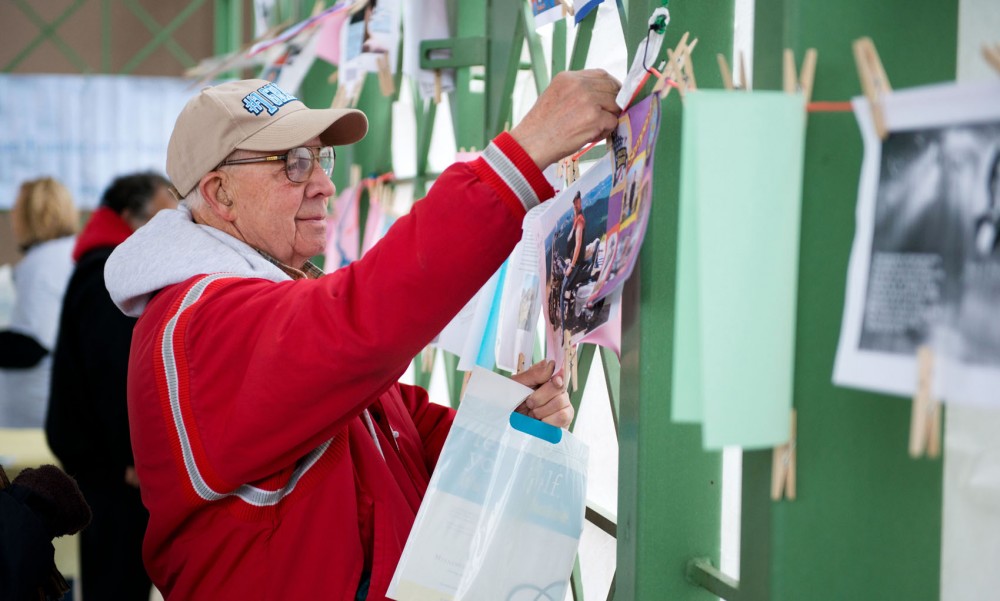 George Metzler hangs up a poster for his son, Chris Metzler, for whom he was walking at Out of the Darkness on Sunday in St. Paul, Minn. (Bridget Bennett)