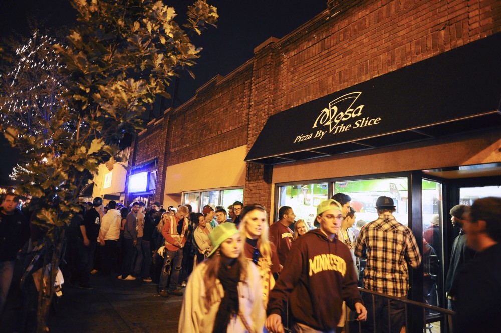Late-night crowds line up for a slice of Mesa pizza during Homecoming weekend in Dinkytown.