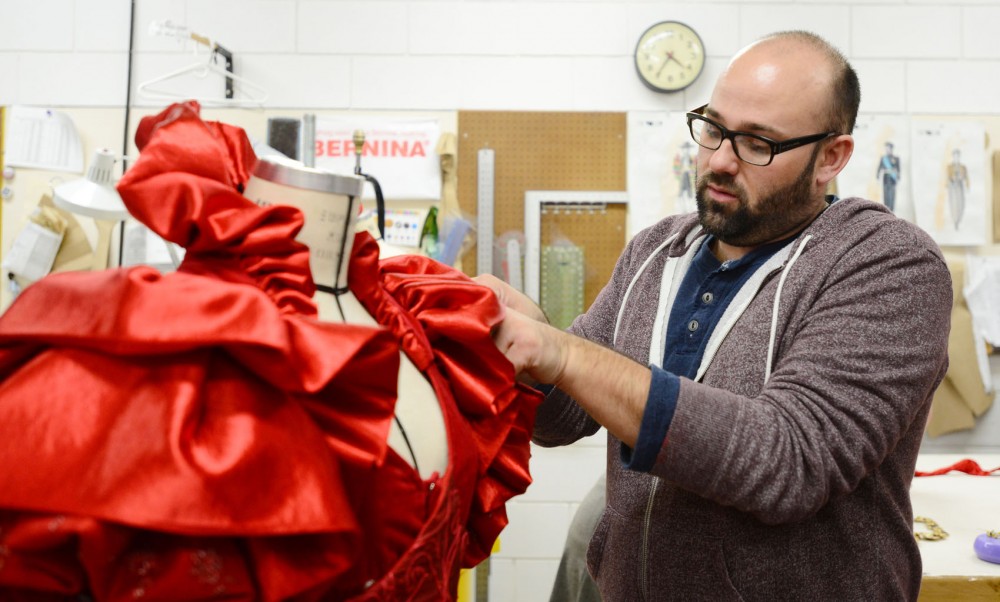 Costume designer Jonathan Singer examines one of the dresses he designed for the play The Rover,