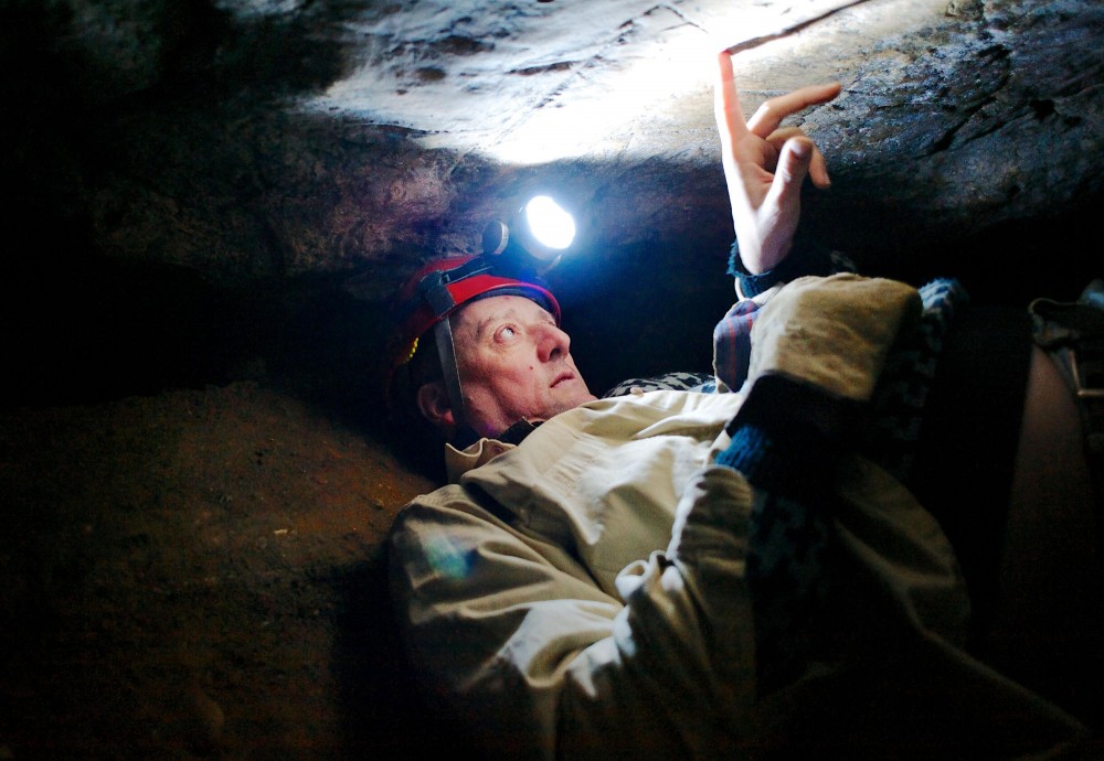 University of Minnesota researcher Greg Brick examines the roof of Miles Cave on Monday, Feb. 4, 2013, beneath Hastings, Minn. Brick has been exploring caves for his research since 2004.