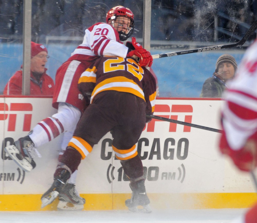 Minnesota forward Travis Boyd (22) checks Wisconsin forward Ryan Little on Sunday at Soldier Field in Chicago. The Badgers beat the Gophers 3-2.