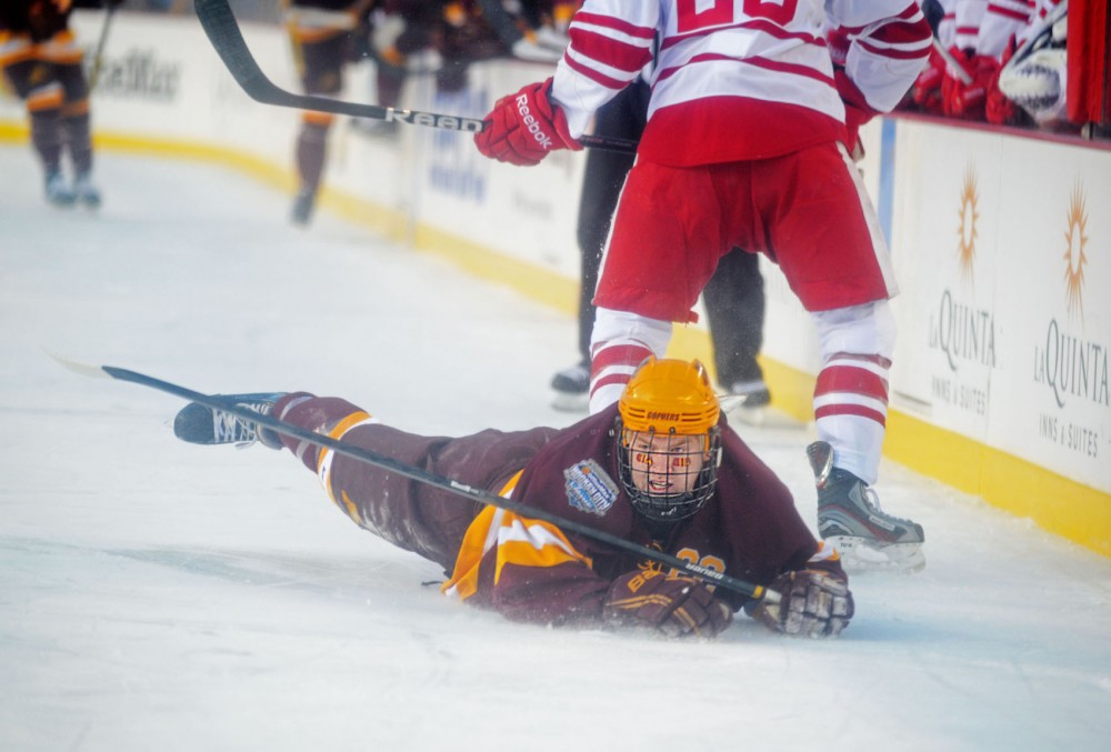 Minnesota forward Travis Boyd (22) slides on the ice on Sunday at Soldier Field in Chicago. The Badgers beat the Gophers 3-2.