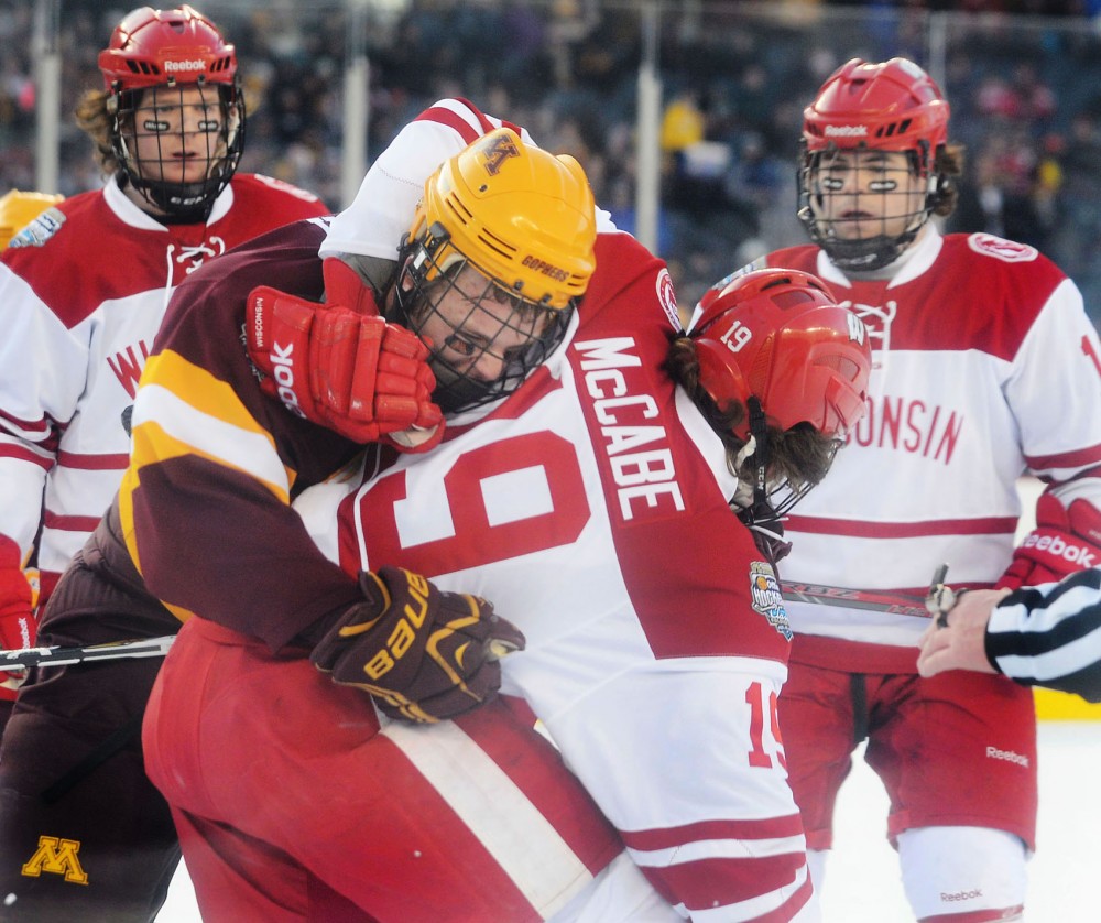 Minnesota forward Zach Budish and Wisconsin forward Mark Zingerle fight Sunday at Soldier Field in Chicago. Both were given penalties for roughing.